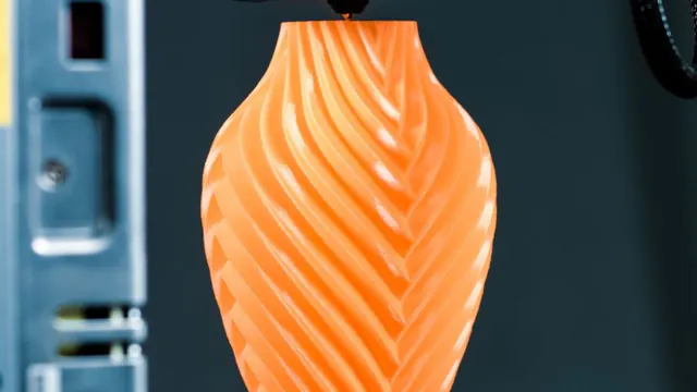Orange vase being made by a 3D printer